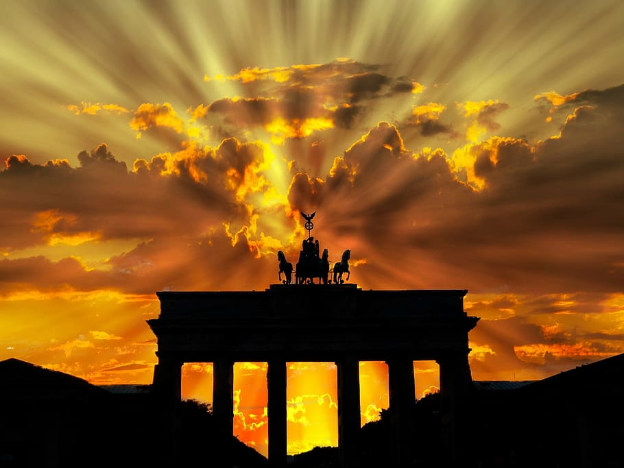 crepuscular rays hitting structure with chariot statue, brandenburger tor
