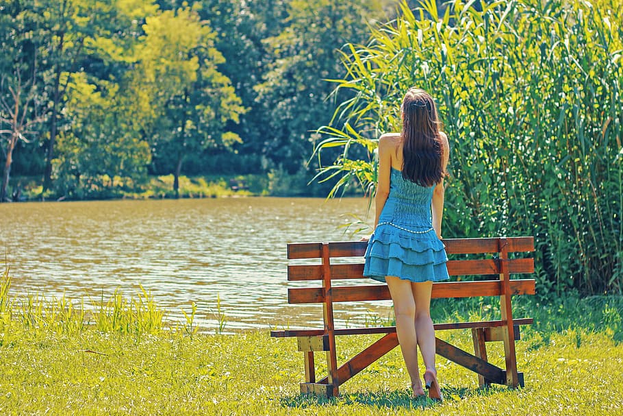 Girl in Blue Dress standing by a bench by a lake, photos, landscape