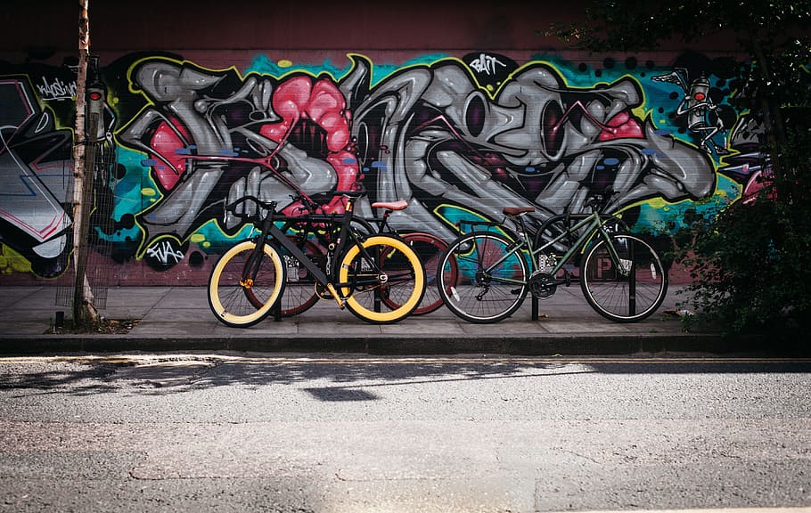 two black and and yellow bikes near wall with graffiti, art HD wallpaper