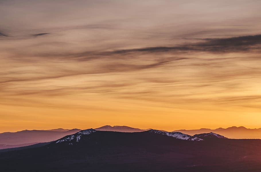 silhouette of mountain during yellow cloudy skies, silhouette photo of mountain under orange sky during golden hour HD wallpaper