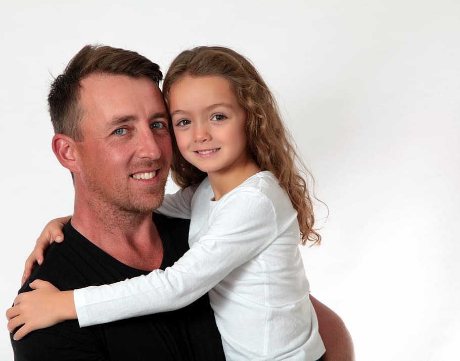 man carrying girl wearing white long-sleeved shirt, father's day