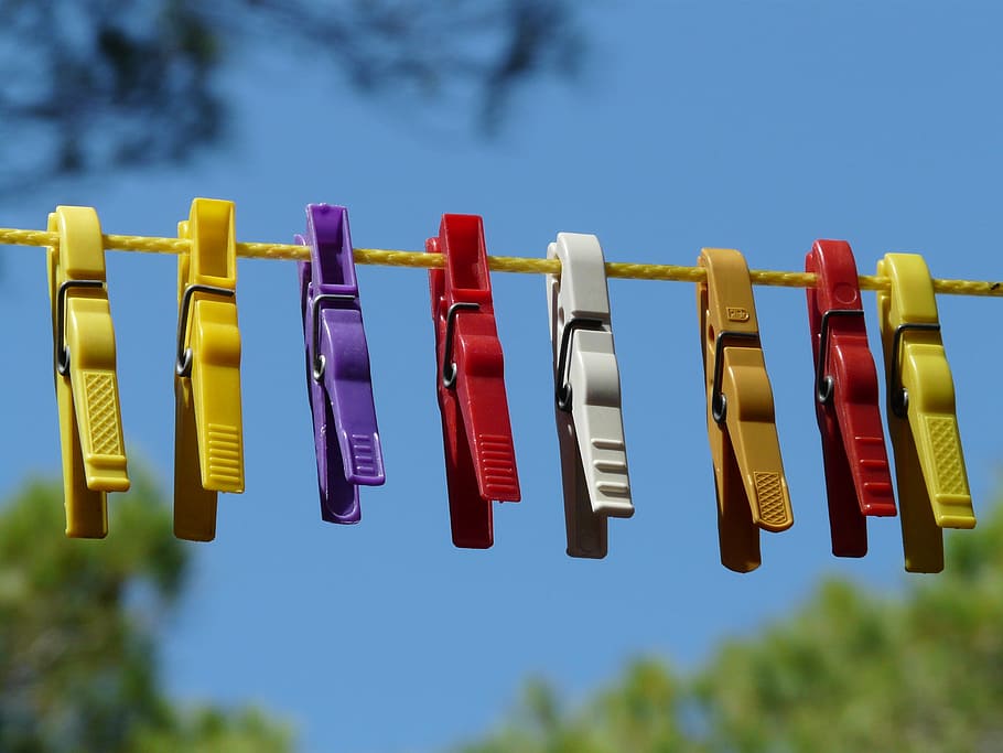 assorted-color clip hanging on yellow string, clothespins, clothes line