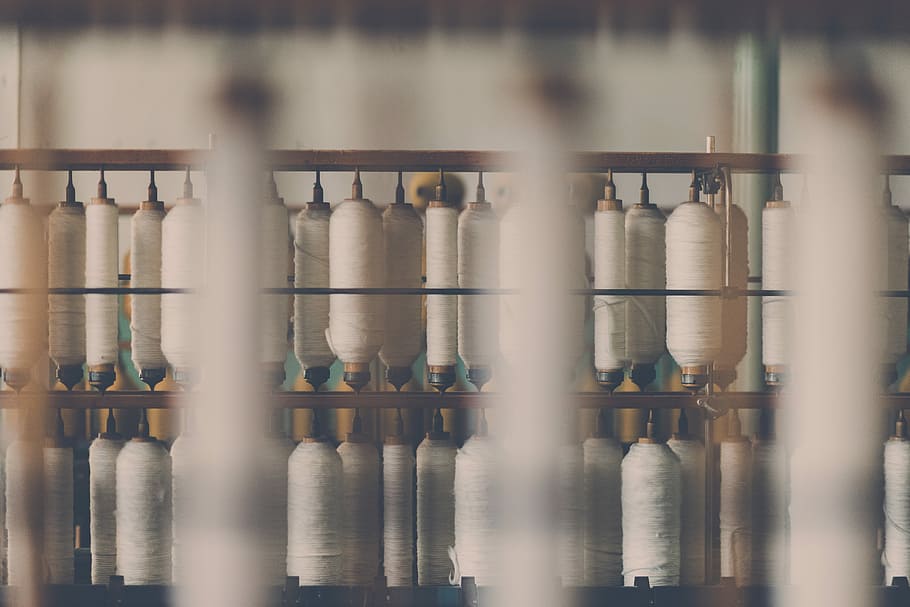 photography of white treadle on brown wooden rack, selective focus photography of sewing thread HD wallpaper