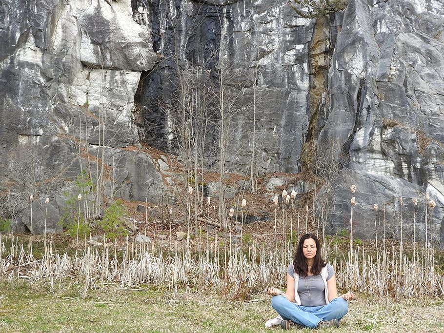 woman meditating beside rock mountain, meditation, peace, relaxation