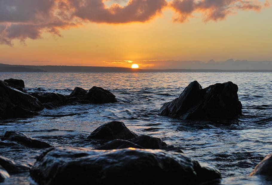 sunset, dusk, ocean, sea, rocks, boulders, clouds, water, horizon HD wallpaper