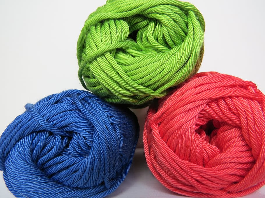 three green, red, and blue yarn rolls with white background, Wool