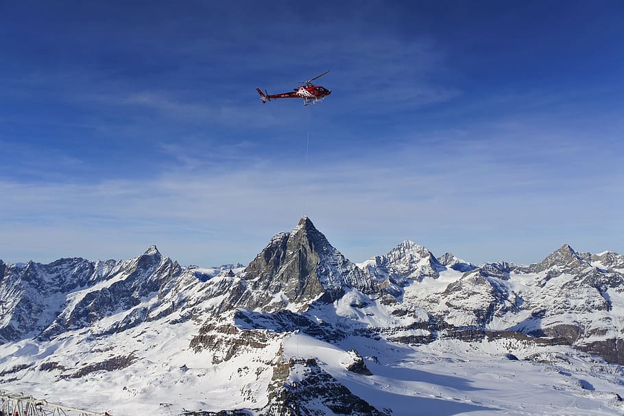 photo of red helicopter flying in snowy mountain, red helicopter above snow filled mountain HD wallpaper