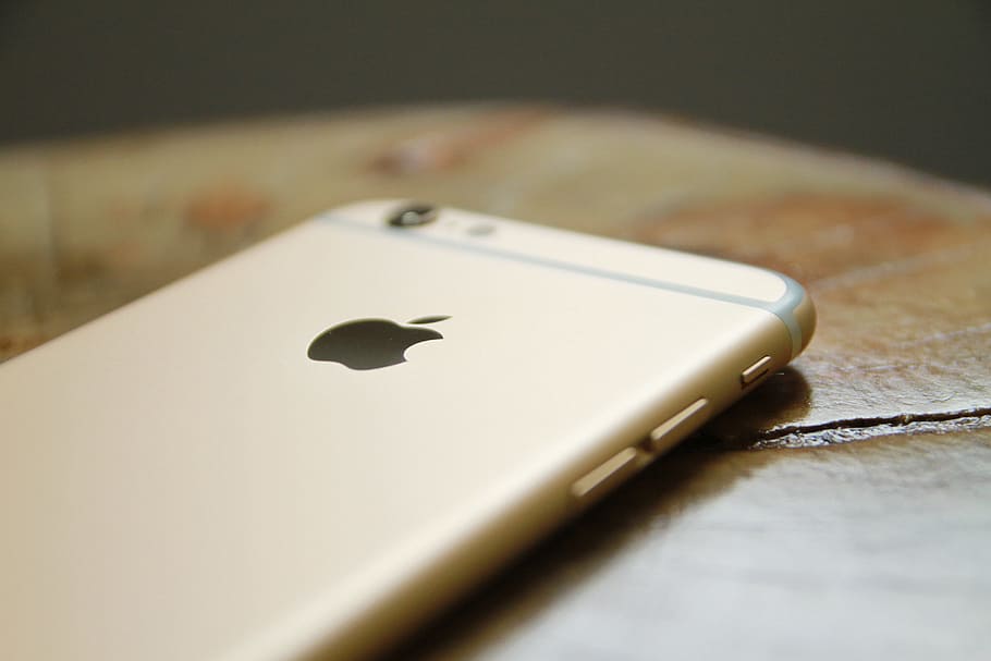 gold iPhone 6, close-up photo of gold iPhone 6 on brown wooden top