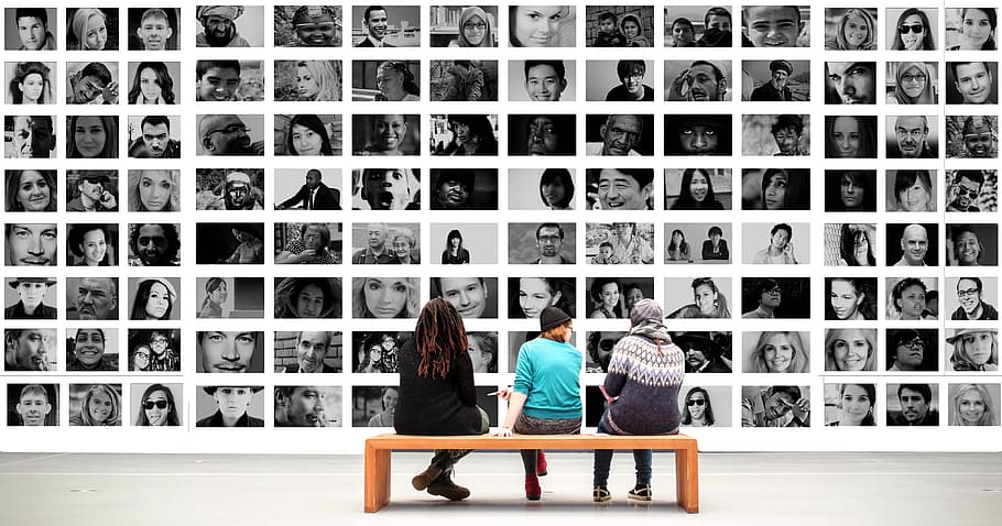 three people sitting on bench in front of collage photos, human