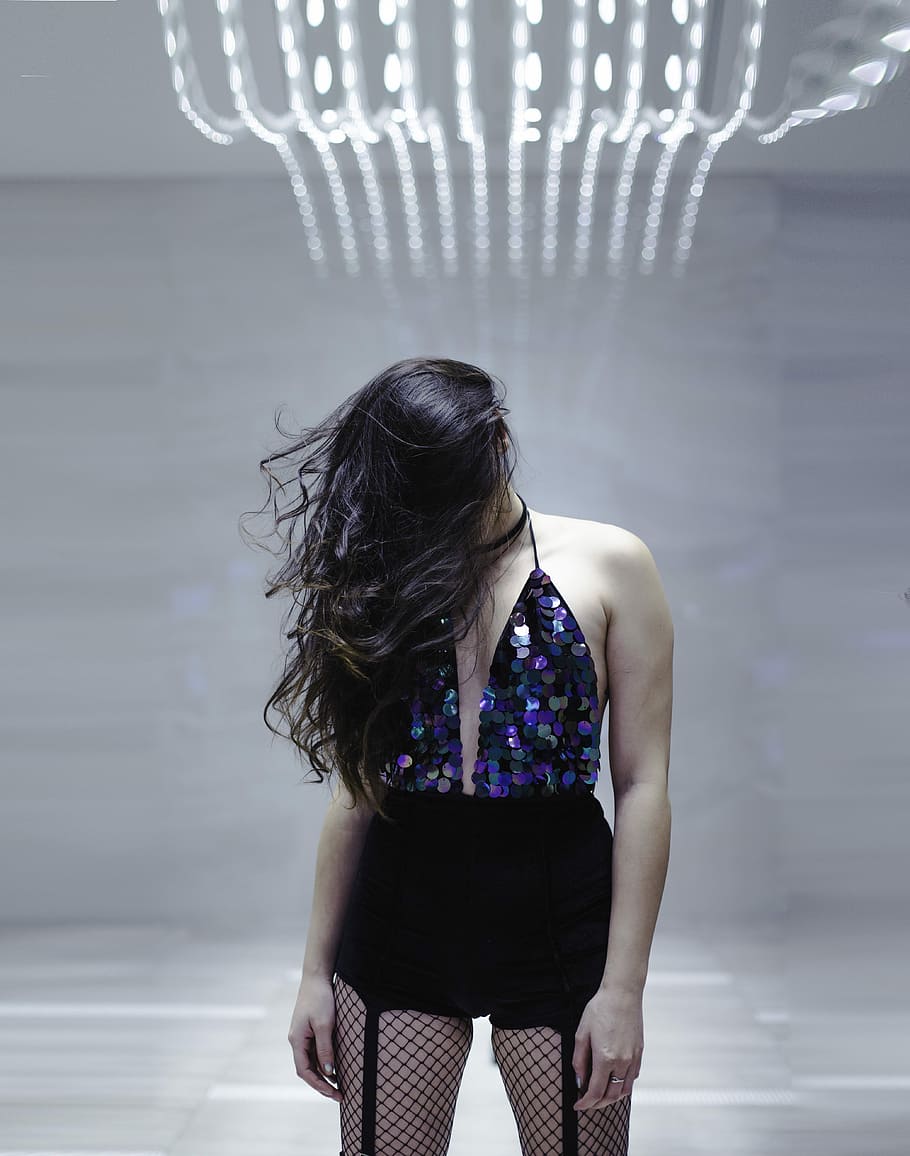 woman standing in middle of white room while bowing her head, woman in blue halter top standing beside gray painted wall HD wallpaper