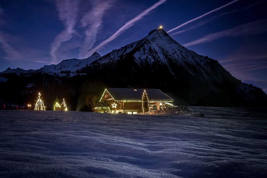 lighted house near mountain during nighttime, house with string lights with snow covered mountain background HD wallpaper