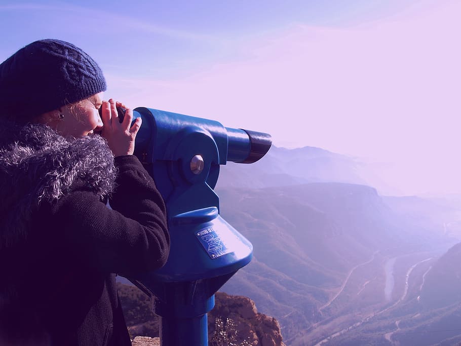woman looking at the hills through scope during daytime, telescope