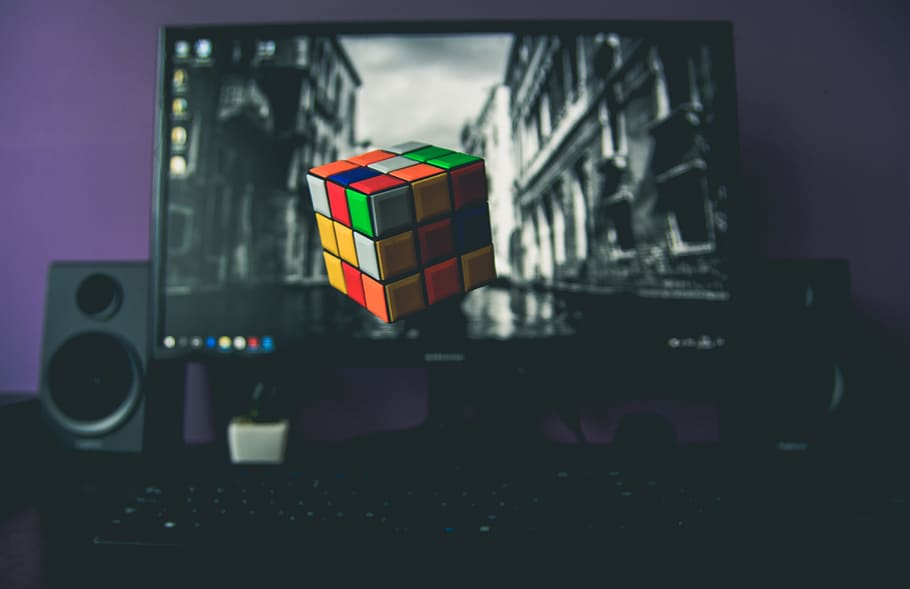 turned on flat screen computer monitor displaying 3x3 Rubik's cube, magic cube floating in front of desktop, HD wallpaper