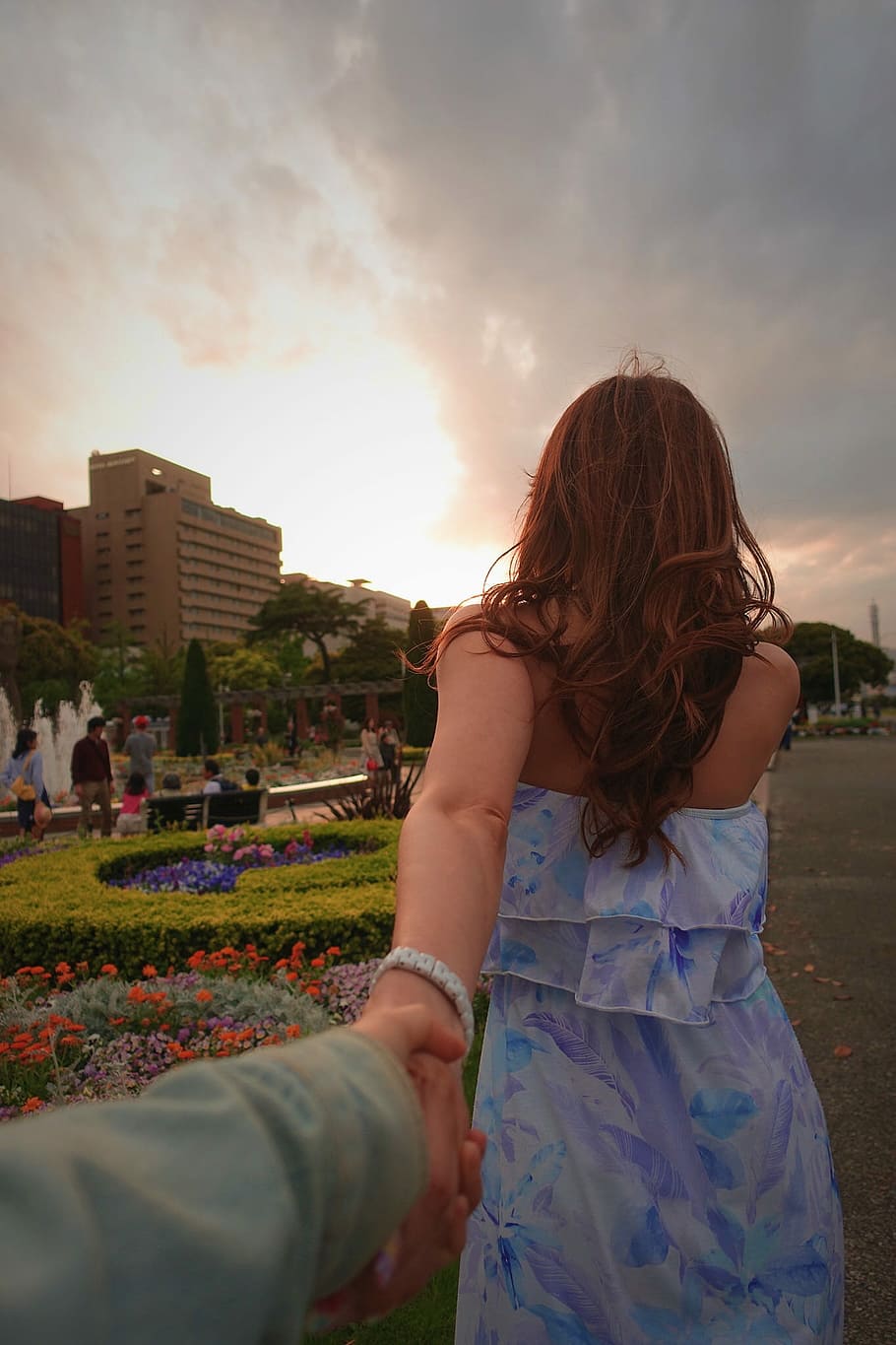 woman wearing blue, white, and purple floral dress turning back holding hand of another person in front of camera, HD wallpaper