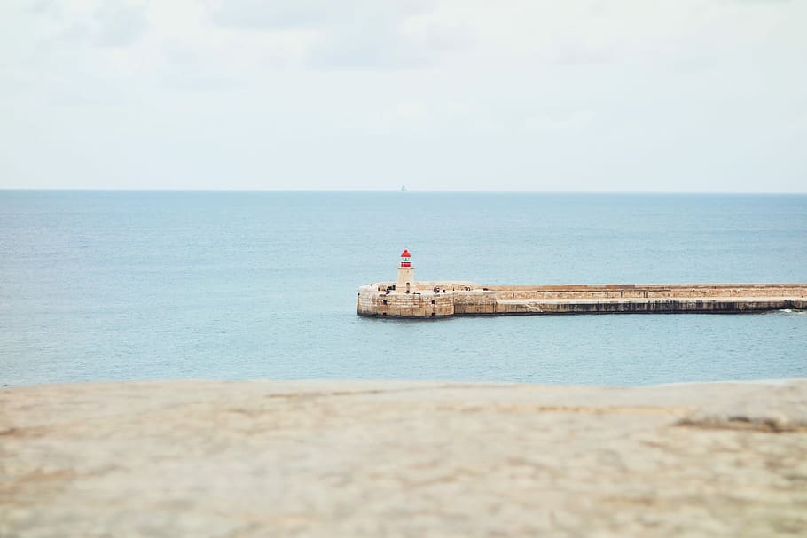 lighthouse surrounded by wide body of water, lighthouse near sea HD wallpaper