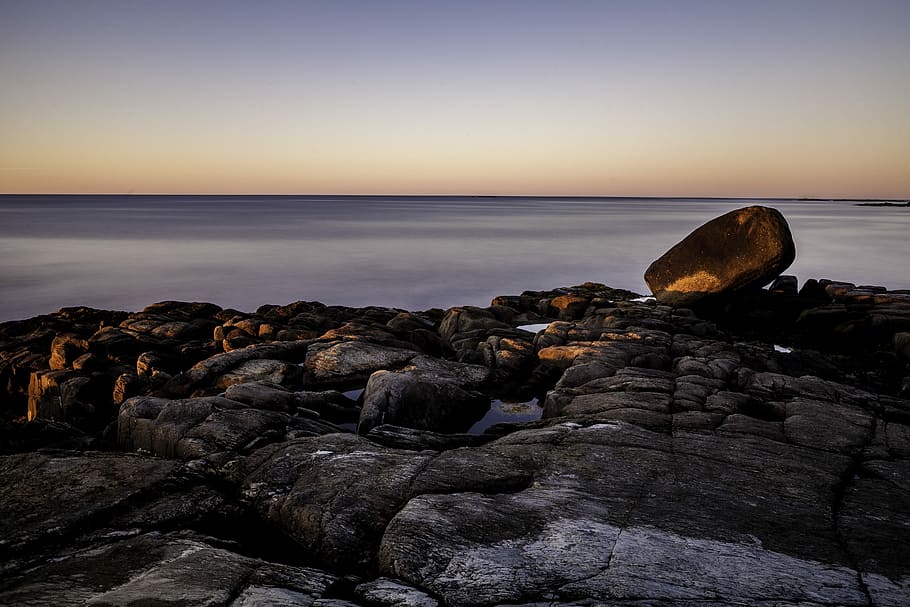 brown rock formation during daytime, rock formation in front calm body of water HD wallpaper