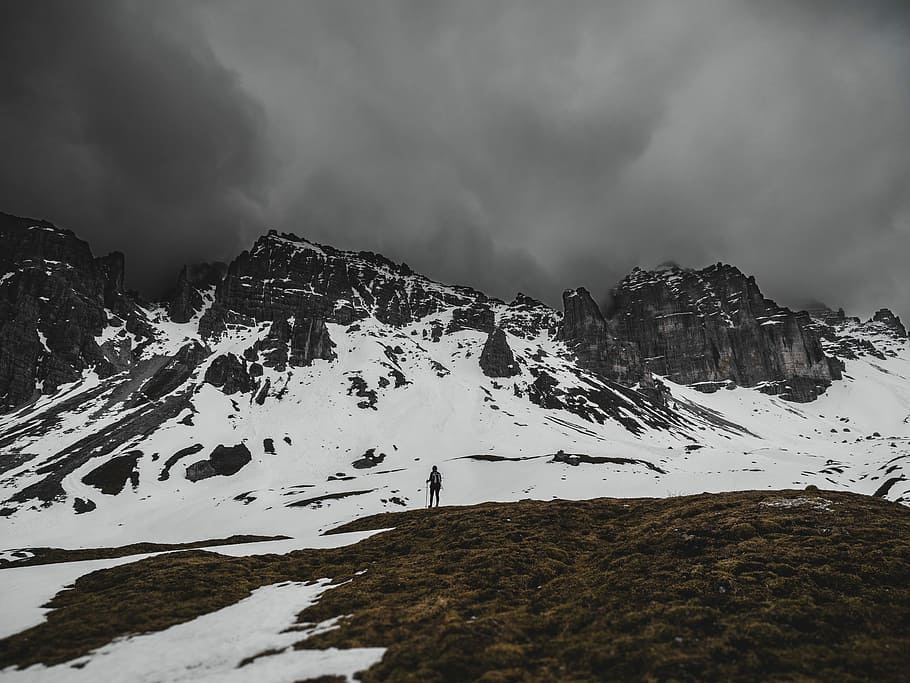 person standing near snow covered mountain taken during daytime HD wallpaper