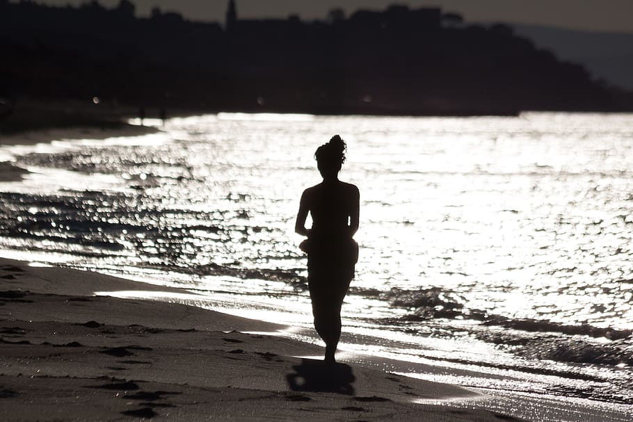 silhouette of woman walker on a sand near sea, person, human