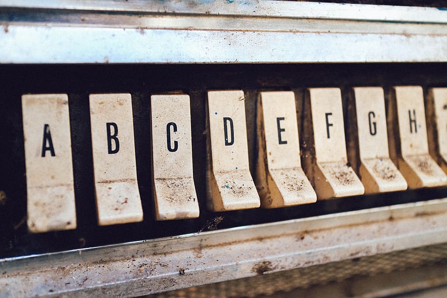close up photography of brown jukebox letter keys, white switch