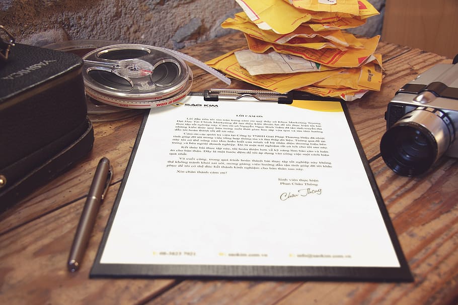 white printer paper clipped on black clipboard on brown wooden table HD wallpaper