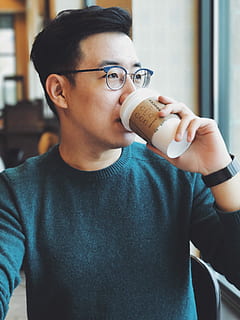 man holding Starbucks disposable cup, man sitting while drinking coffee HD wallpaper