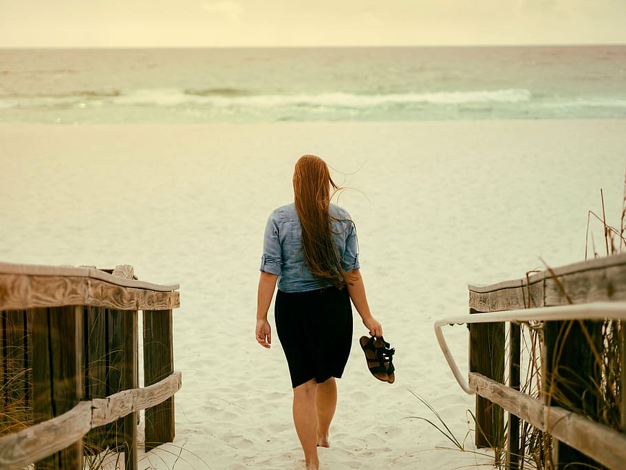 woman holding pair of sandals while walking on sand, blue, sleeve HD wallpaper
