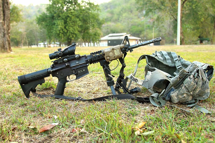 black assault rifle with scope beside gray tactical vest on green grass field photo, HD wallpaper