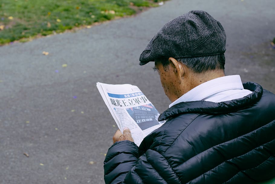 man reading newspaper, senior, cap, quilted coat, collar, back