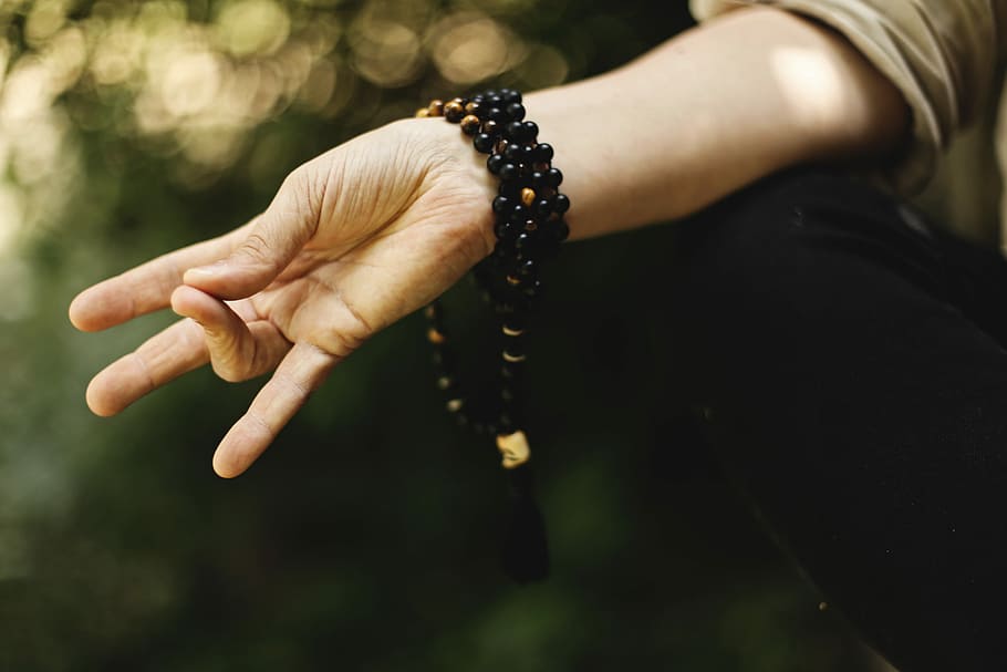 left hand with bracelets, person doing hand sign, bead, wrist