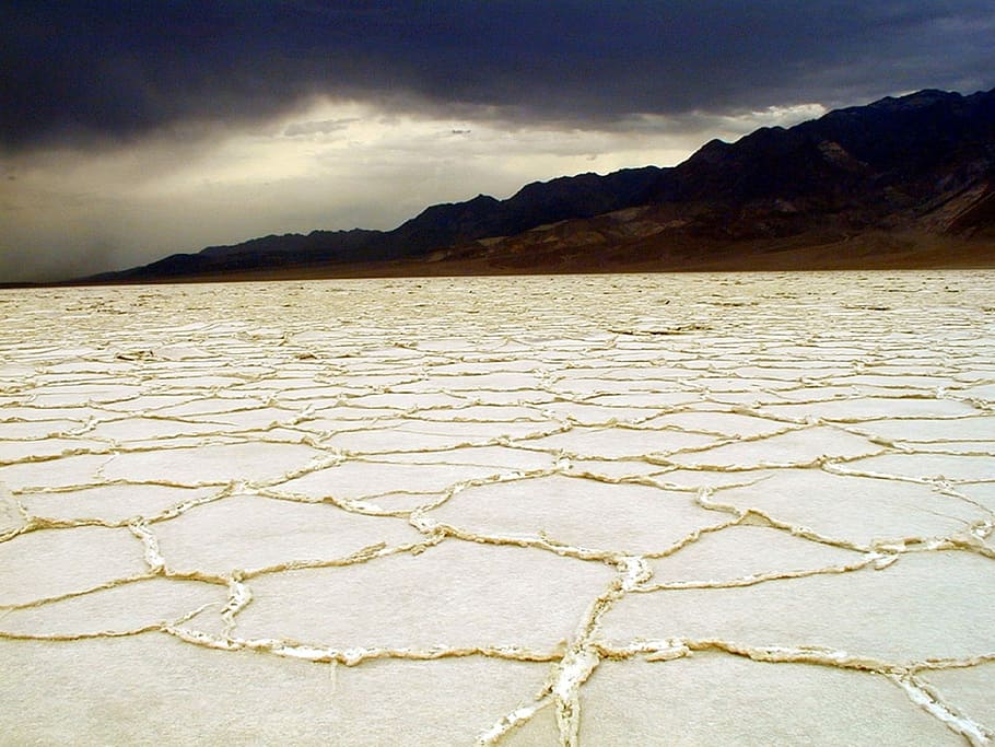 landscape photography of dry ground near mountain under nimbus cloud HD wallpaper