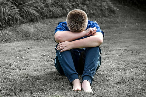 man wearing blue t-shirt and black pants sitting over grass field HD wallpaper
