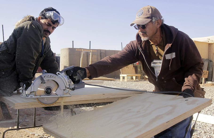 man using circular saw on cutting the board, men working, construction