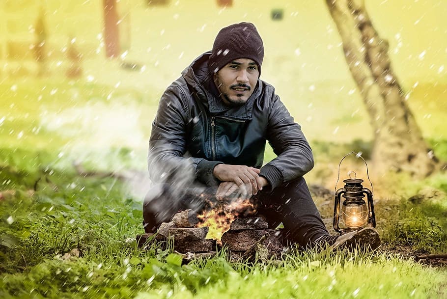 man sitting on green grassland, fireplace, cold, outdoor, snow, HD wallpaper