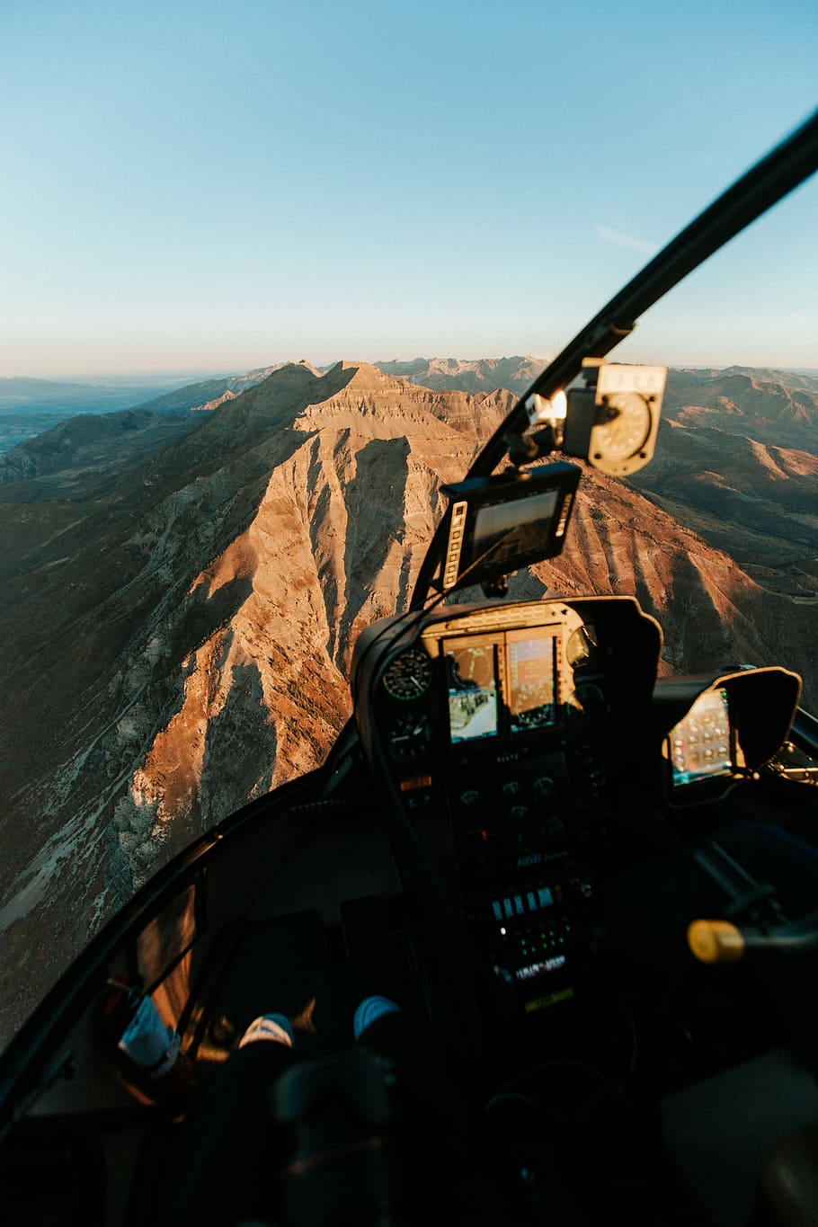 man driving plane on top of mountain, person riding helicopter over brown mountain HD wallpaper