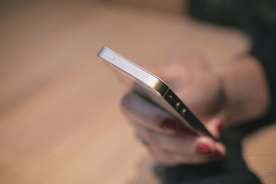 person holding gold iPhone 5s selective-focus photo, table HD wallpaper
