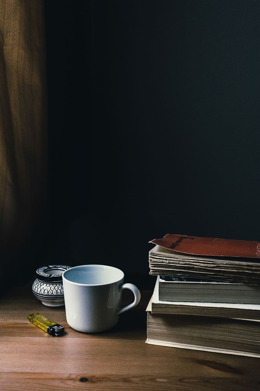 white ceramic mug beside books and disposable lighter, white ceramic mug on brown wooden table HD wallpaper