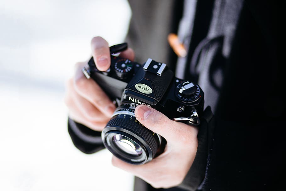 A photographer man holding a black retro camera, technology, camera - Photographic Equipment