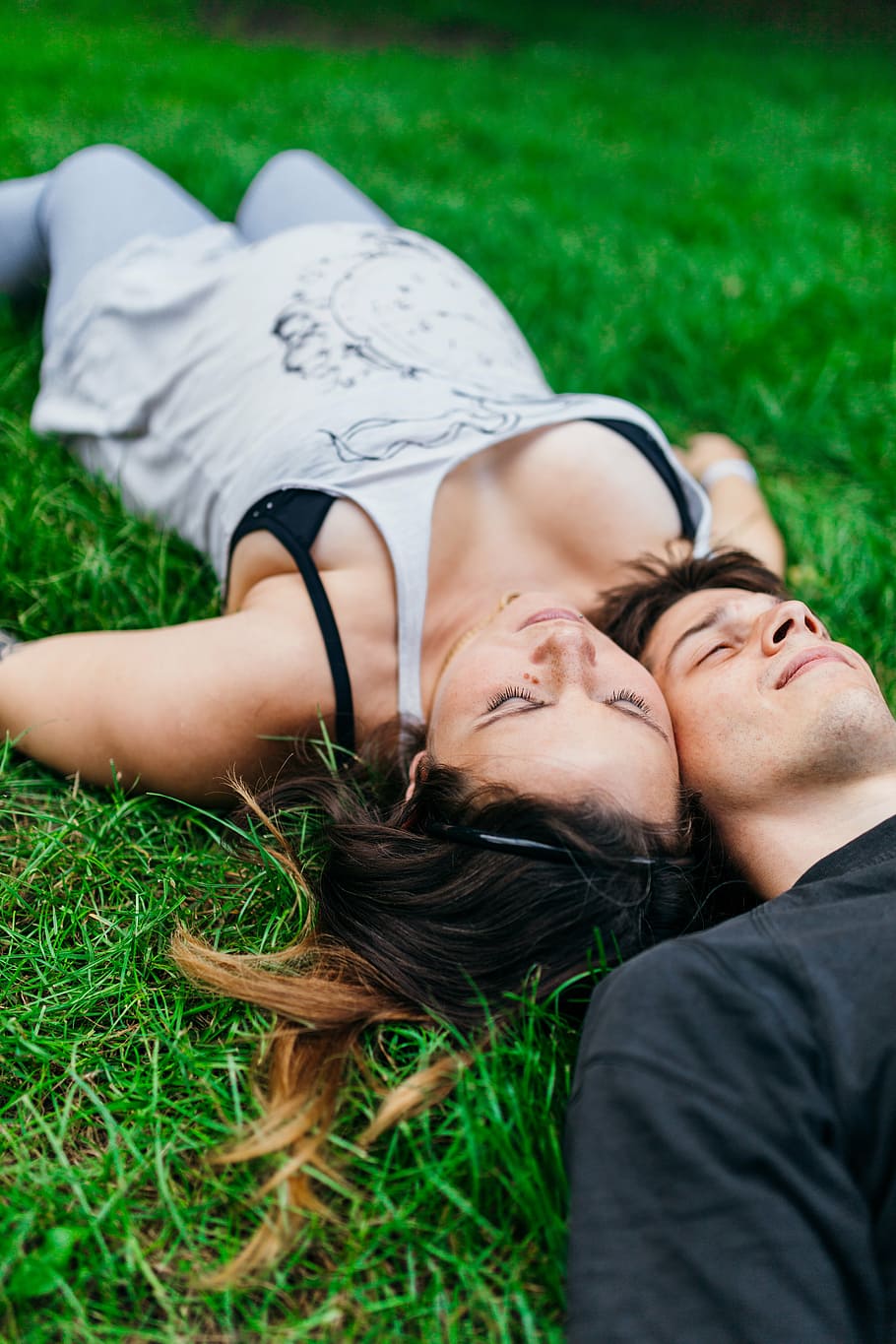 man and woman laying on the floor, couple, grass, park, casual