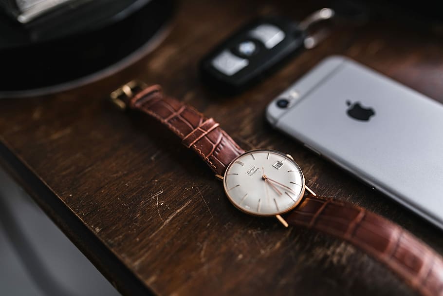 Apple iPhone 6 and Vintage watch on a brown leather wallet, technology