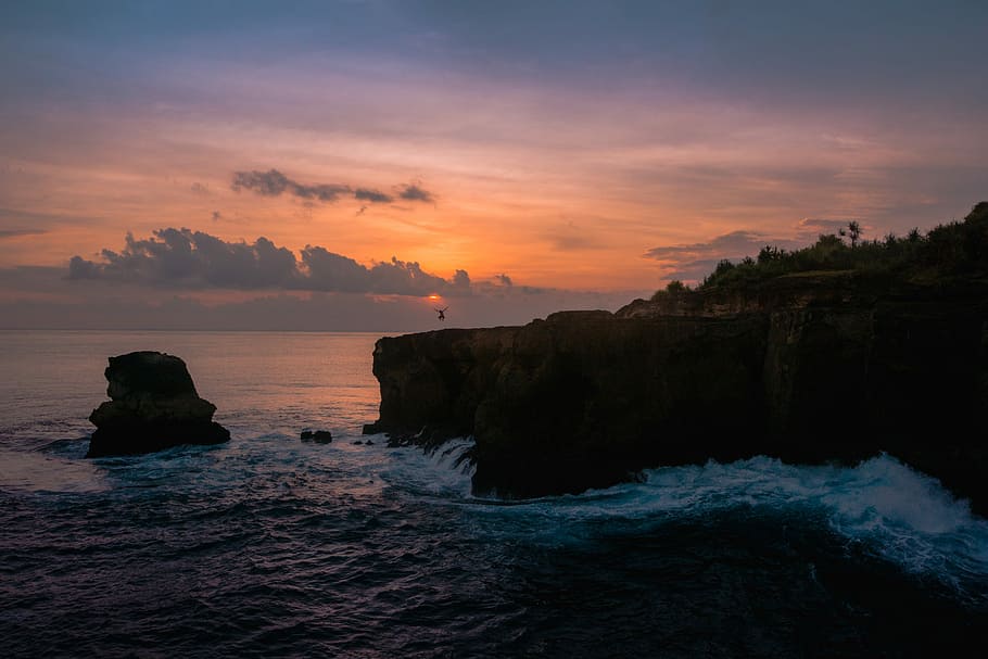 body of water splashing on rocks during golden hour, long exposure photography of ocean HD wallpaper