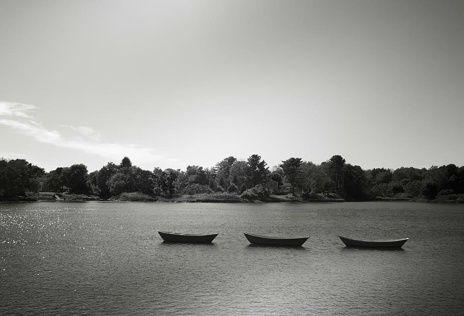 grayscale photography of three boats on body of water, middle
