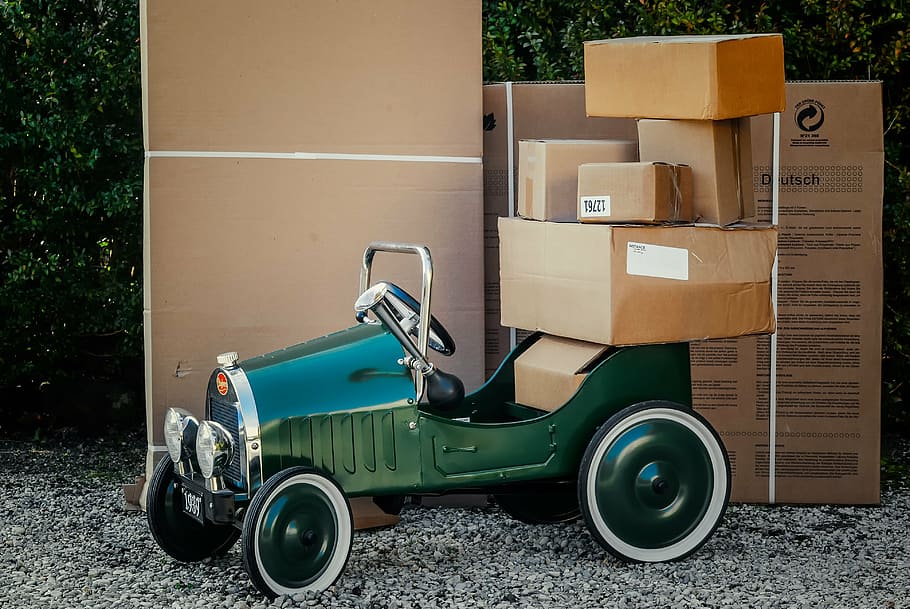 classic green car loaded with brown cardboard boxes, package