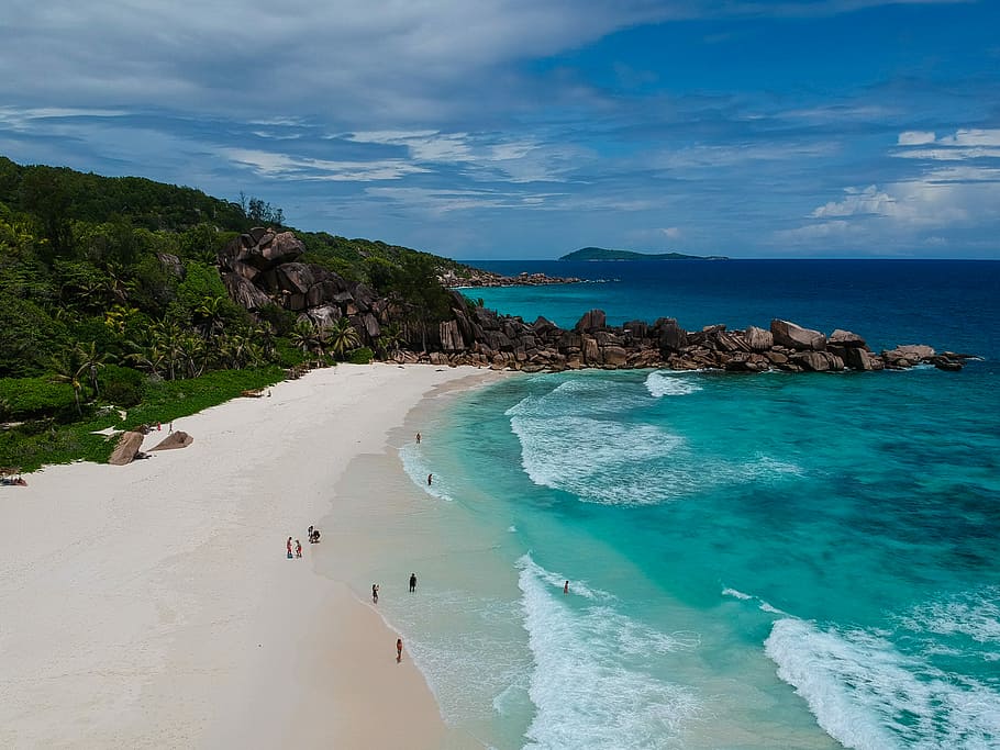 aerial view photography of seashore near mountain under cumulus clouds, landscape photography of coastline HD wallpaper