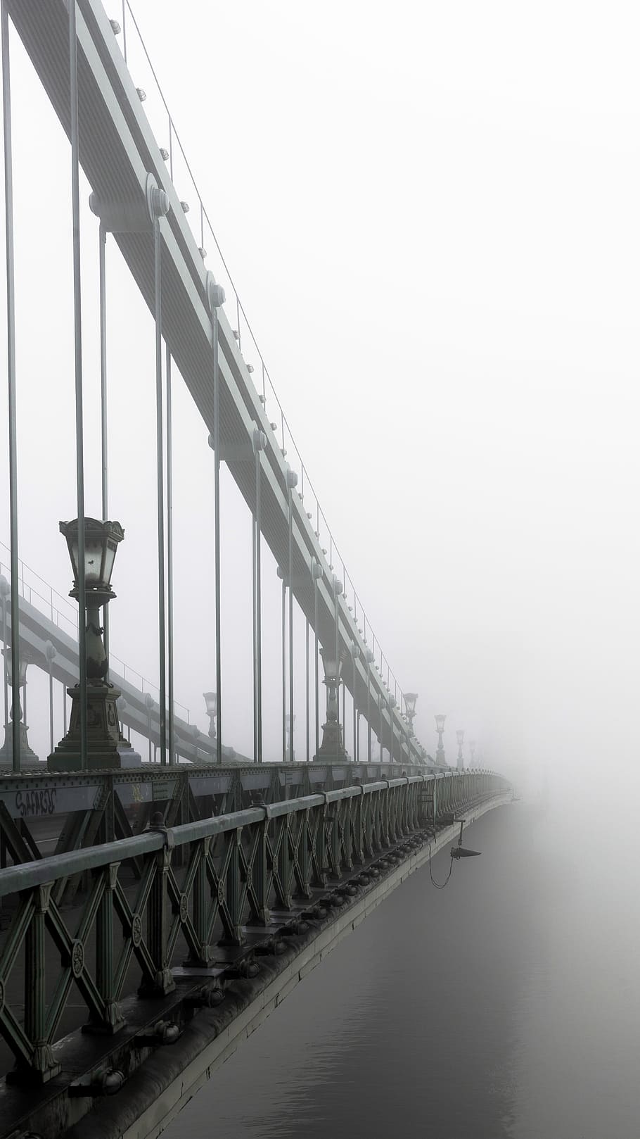 closeup photo of bridge and mist, grayscale photo of suspension bridge