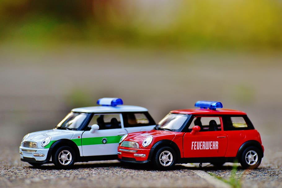 shallow depth of field photo of two red and white Mini Cooper scale models