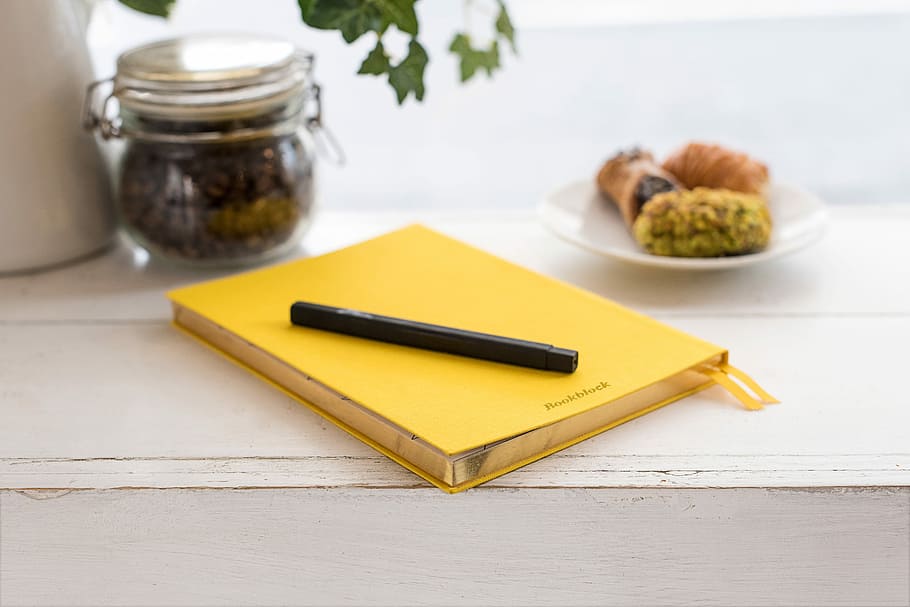 pen on book binder, black pen on top of yellow book near jar and saucer, HD wallpaper