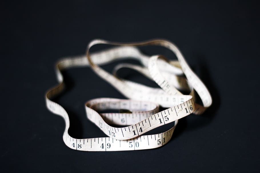 selective focus of white and black tape measure on black surface