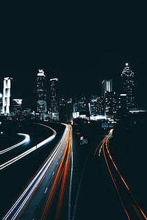 time-lapse of photography vehicle on road in distant of high rise buildings HD wallpaper