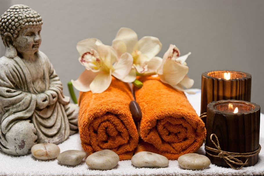two orange fleece receiving towels beside brown-tinted glass votives HD wallpaper