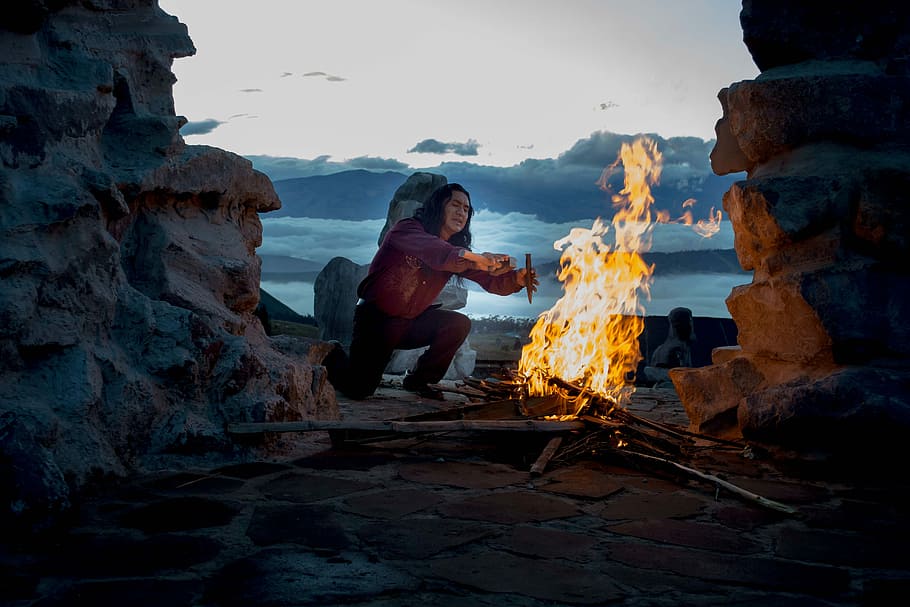 person kneeling in front of bonfire outside, man near bonfire HD wallpaper
